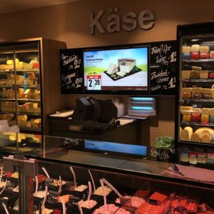 Angebotswerbung für Käse auf einem Großformatbildschirm beim Einzelhändler EDEKA Meibohm